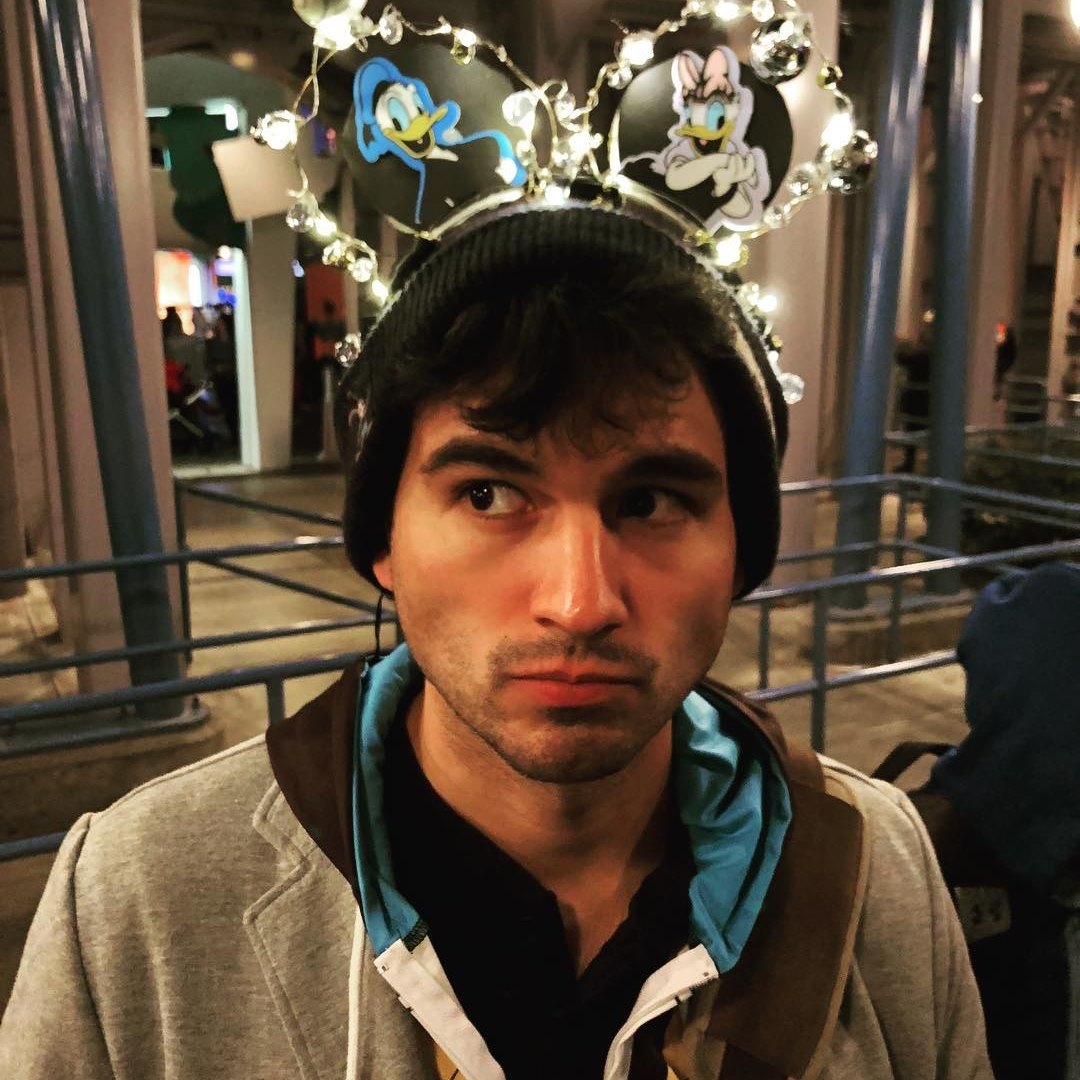Robert Acosta wearing glowing Donald and Daisy mouse ears at Disneyland.