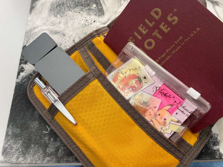 An 86 Lux reading light and a small pouch of Pokemon note tabs.