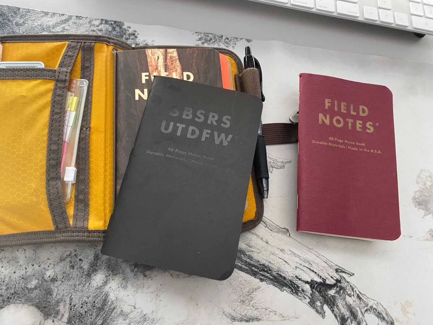 A Lochy Mini Field Journal with a Field Notes inside being swapped out for another Field Notes.