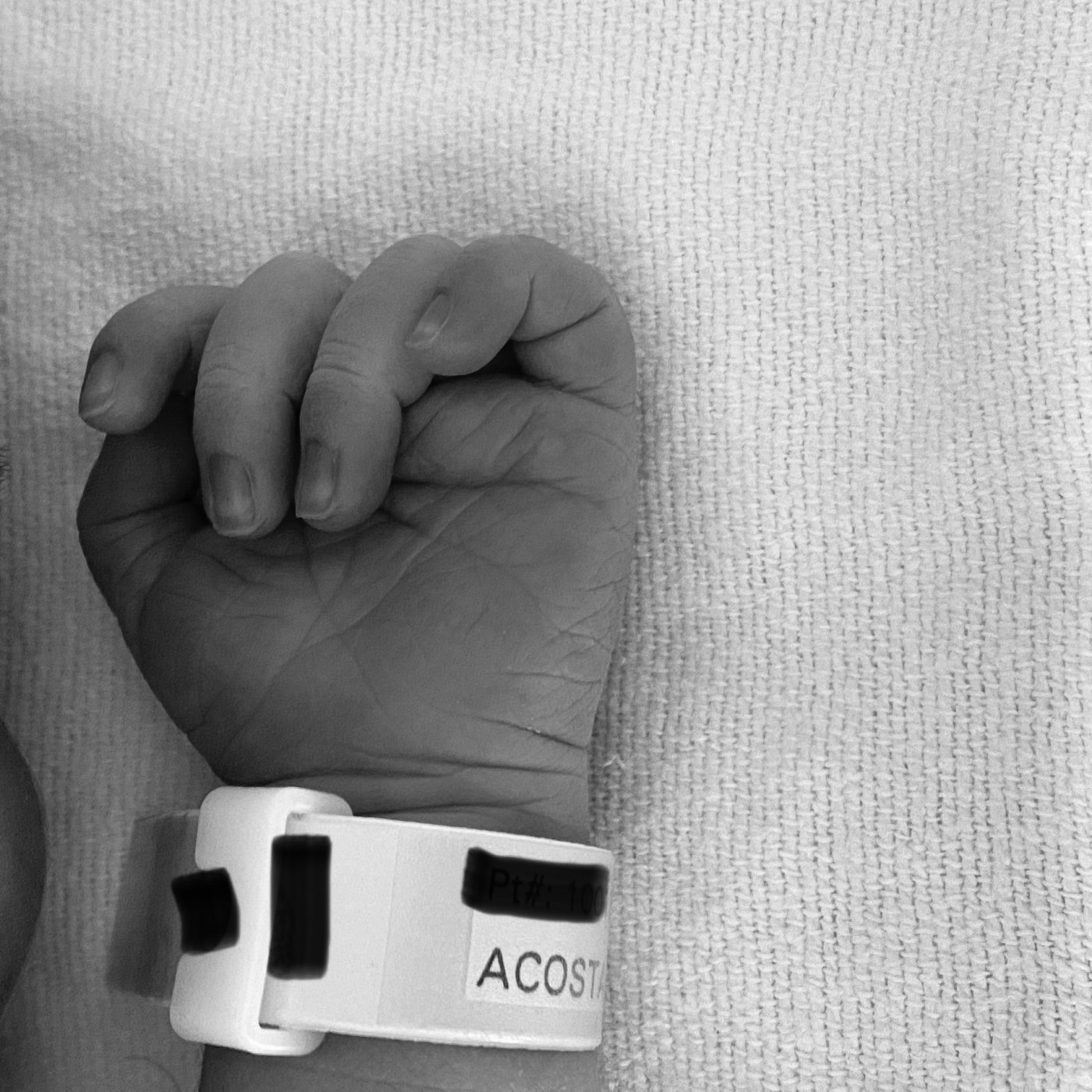 A black and white photo of a newborn baby's hand.