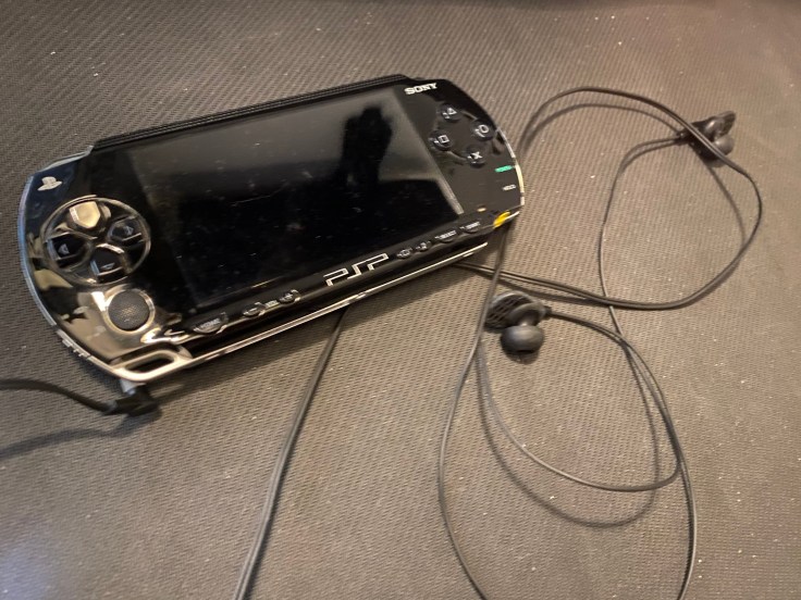 A PSP with a set of wired earbuds